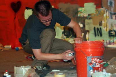 Derek painting a bucket in his studio.