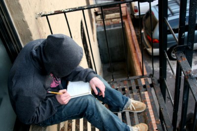 Derek hanging out on a fire escape working out ideas in a sketchbook. (image courtesy the artist)