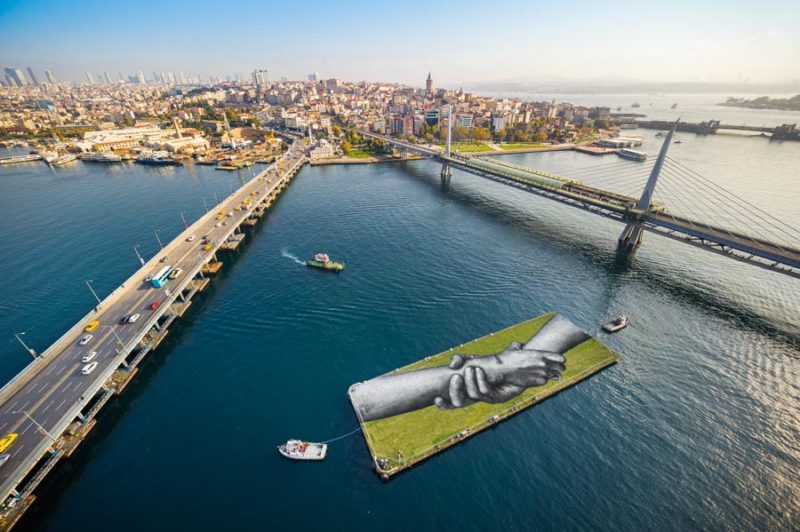 Saype Brings Symbol of Joined Hands to East/West Precipice in Istanbul